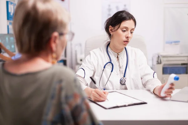 Mediziner schreiben Patientendiagnose — Stockfoto