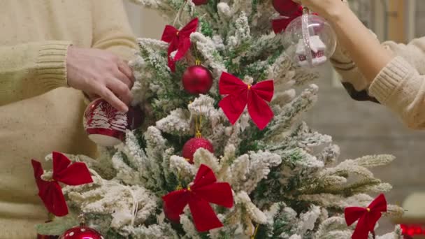 Primer plano de pareja joven decorar árbol de Navidad — Vídeos de Stock