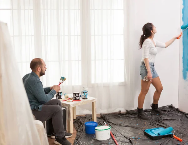 Marido descansando enquanto sua esposa pintura — Fotografia de Stock