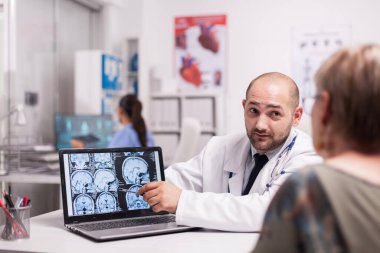 Doktor yaşlı kadınla konuşuyor.
