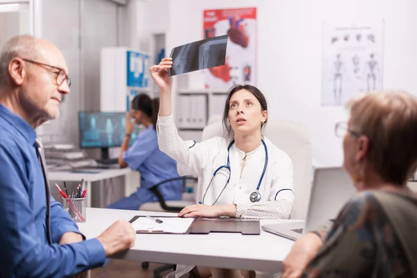 Kobieta lekarz patrząc na prześwietlenie pacjenta — Zdjęcie stockowe
