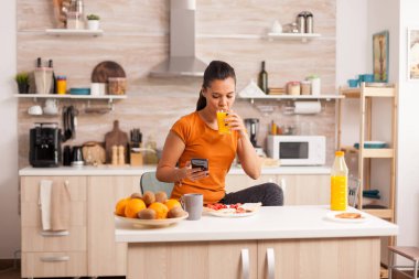 Taze portakal suyu içiyor.