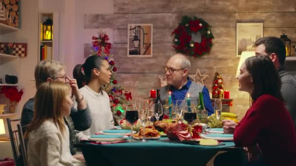 Abuelo a la cabeza de la mesa mientras se celebra la Navidad — Vídeos de Stock