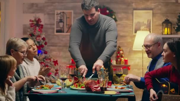 Hombre adulto rebanando el pollo para la celebración de Navidad — Vídeo de stock