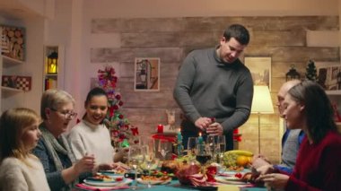 Baba bir şişe şarap açarken heyecanlı aile fertleri