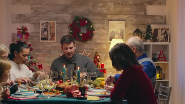 Familia alegre disfrutando de sabrosa comida para la reunión de Navidad — Vídeos de Stock