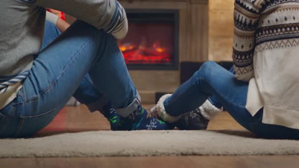 Молодая пара с теплыми носками перед камином — стоковое видео