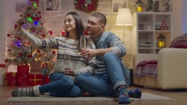 Noel günü şampanya içen sevimli bir çift.