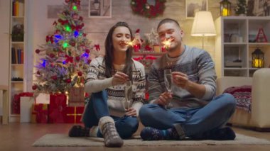 Mutlu çift Noel gününde el ele tutuşuyor havai fişekler