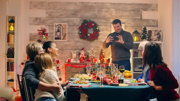 Hombre adulto tomando una foto con la familia en la reunión de Navidad —  Fotos de Stock