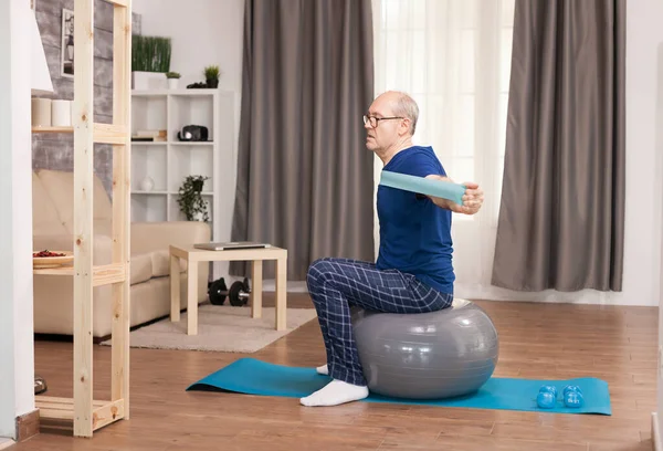 Pensioner doing sport with resistance band