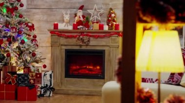 Işıklı bir Noel ağacının altında sunar