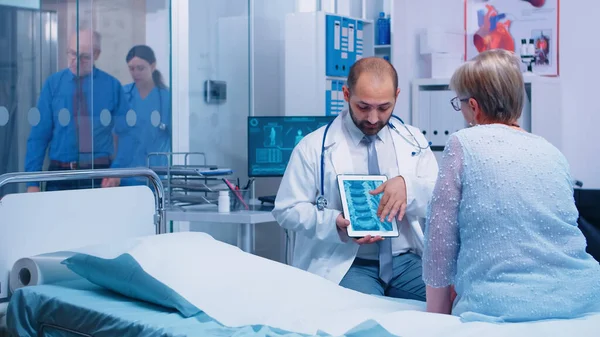 Dottore che presenta la scansione a raggi X su tablet digitale — Foto Stock