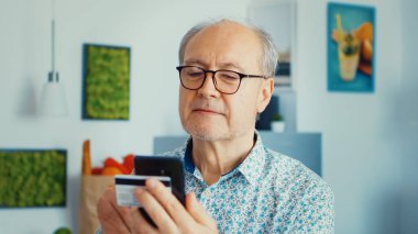 Kıdemli adam internetten alışveriş yapıyor.