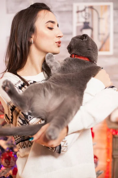 Cheerful young woman trying to kiss her cat — Stock Photo, Image
