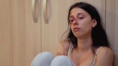 Tacize uğramış kadın yerde oturuyor.