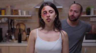 Yaralı bir kadın kameraya bakıyor.