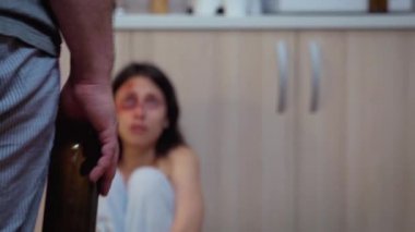 Alkolik koca korkmuş karısına bakıyor.