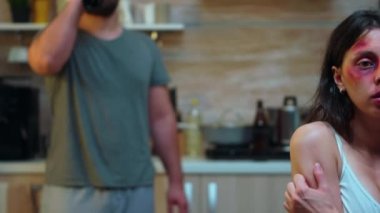 Şarap içiyor ve karısını taciz ediyor.