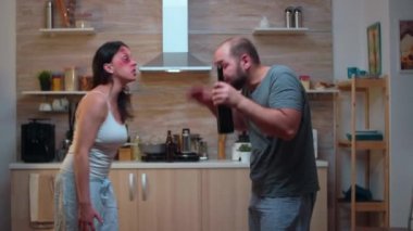 İncinmiş eş sarhoş kocaya bağırıyor.