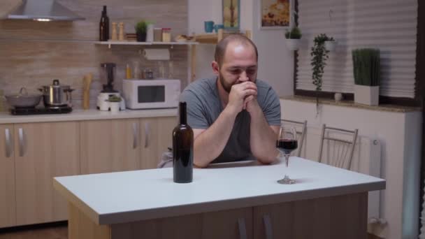 Грустный муж пьет на кухне — стоковое видео