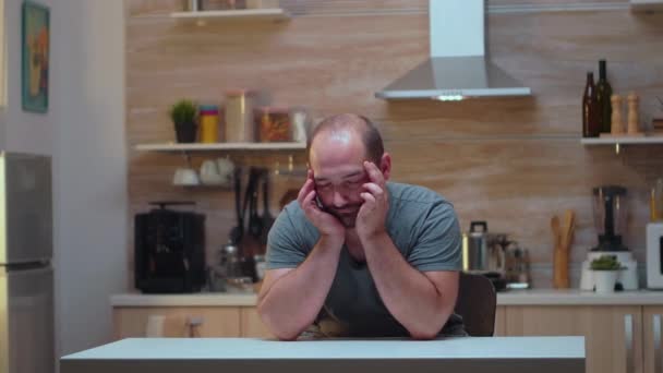 Fejfájós férfi ül a konyhában. — Stock videók