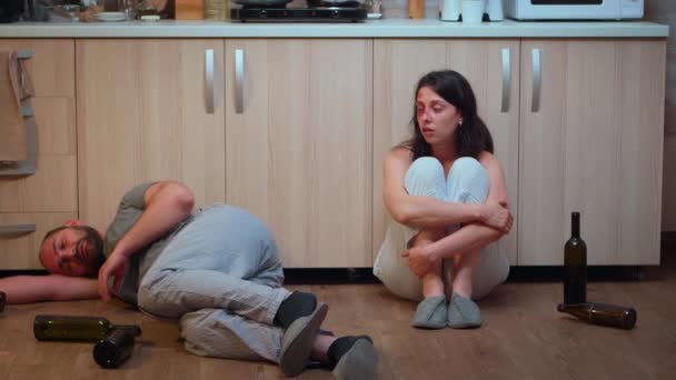 Frau trinkt Alkohol neben betrunkenem Ehemann — Stockvideo