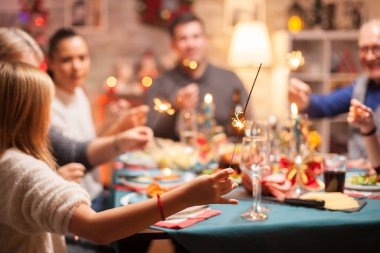 Küçük kız havai fişekleri tutuyor.