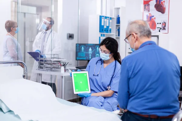 Hasta yeşil ekranlı tablete bakıyor — Stok fotoğraf