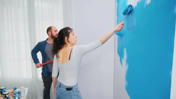 Муж и жена рисуют стену — стоковое фото