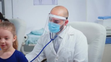 Doktor muayenehanesinde kız kontrolü yapıyor.