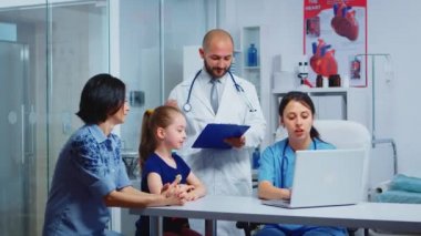 Anne ve kızı sağlık görevlileriyle konuşuyor.