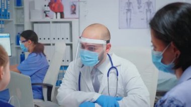 Çocuk ve erkek doktor konuşuyor ve gülüyor.