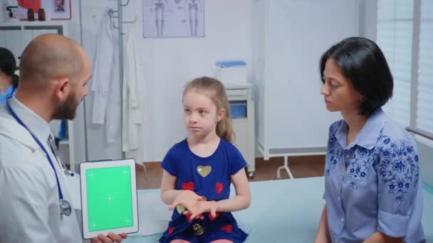 Médico falando e segurando um tablet tela verde — Vídeo de Stock