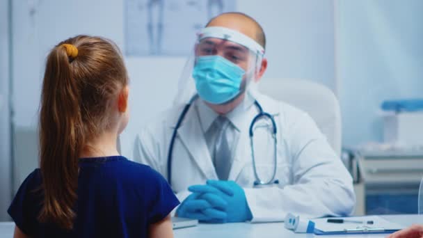 Freundlicher Arzt im Gespräch mit kleinem Patienten — Stockvideo