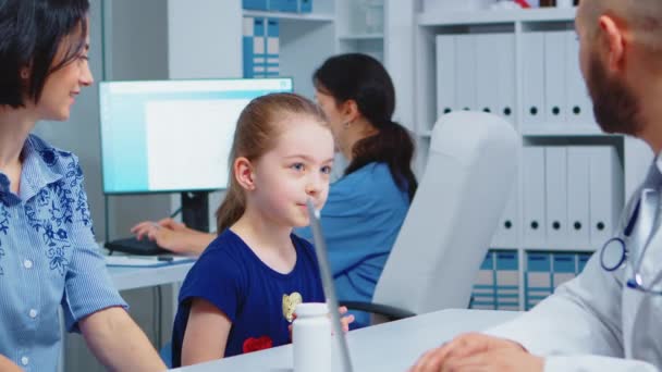 Médico conversando com criança e mãe — Vídeo de Stock