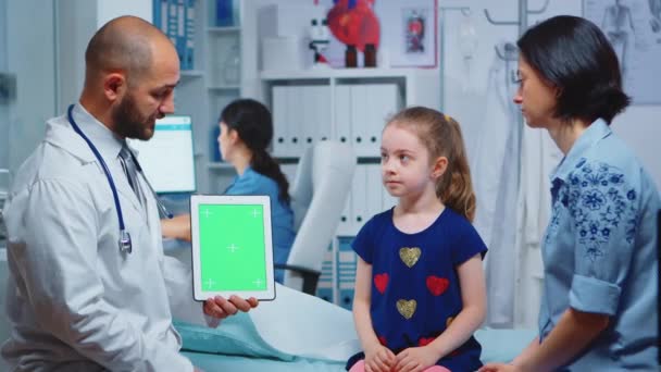 Лікар і пацієнти дивляться на планшет із зеленим екраном — стокове відео