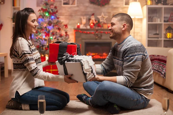 Cheerful boyfriend giving his girlfriend a gift