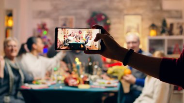 Kız telefonuyla aile fotoğrafı çekiyor.