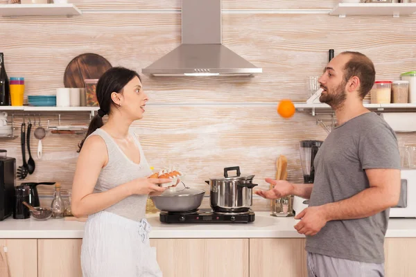 Marido brincando com uma laranja — Fotografia de Stock