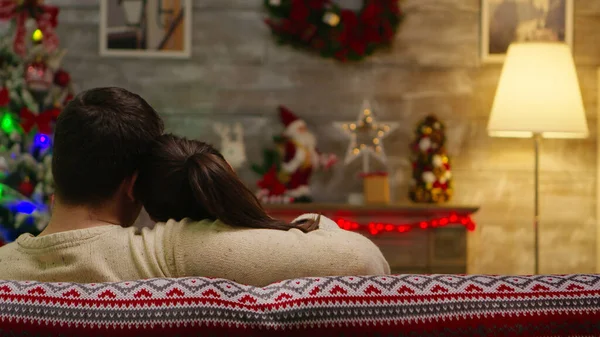 Back view of romantic couple sitting on couch