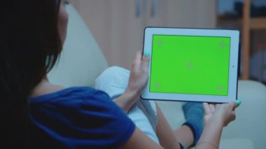 Yeşil ekranlı dijital tablette okuyan kadın