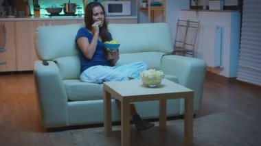 Kanepede oturup televizyon izleyen bir kadın.