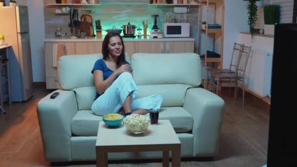Mujer sentada en el sofá viendo la película — Vídeos de Stock
