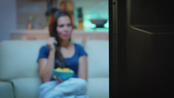 Senhora comer lanches enquanto assiste tv — Vídeo de Stock