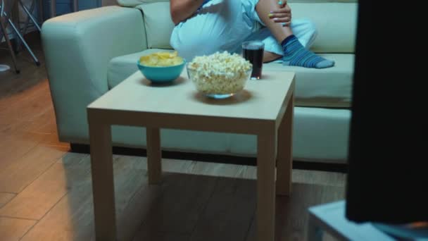 Žena drží dálkové ovládání a jíst popcorn — Stock video