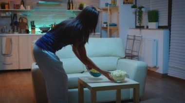 Yılanlarla istirahat eden kadın film izliyor.