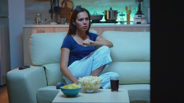Самотня жінка дивиться телевізор увечері — стокове відео