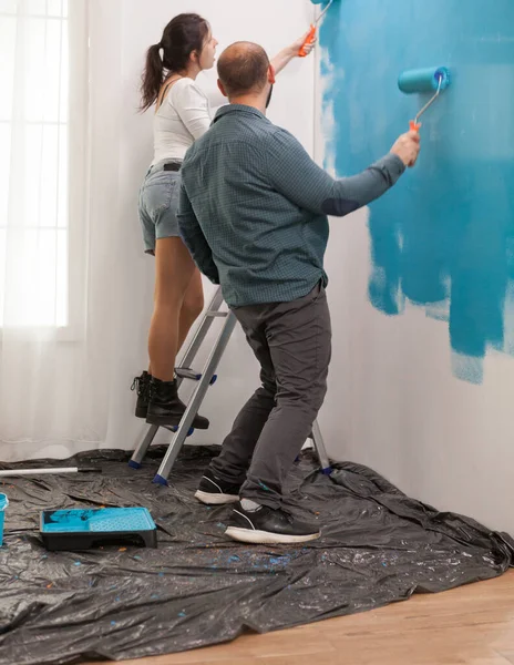 Esposa en la pintura escalera con rodillo — Foto de Stock