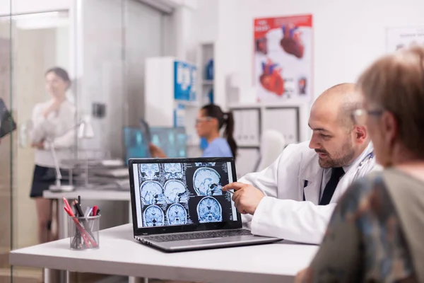 컴퓨터로 ct 스캔을 가리키는 뇌 외과의 — 스톡 사진